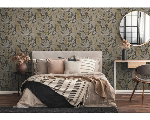 Schlafzimmer mit gemusterten Tapeten, Bett, Tisch, Stuhl und Spiegel