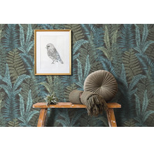 Szene mit Farnmuster-Tapete, einem gerahmten Vogelbild und Dekorationen auf einem Holztisch