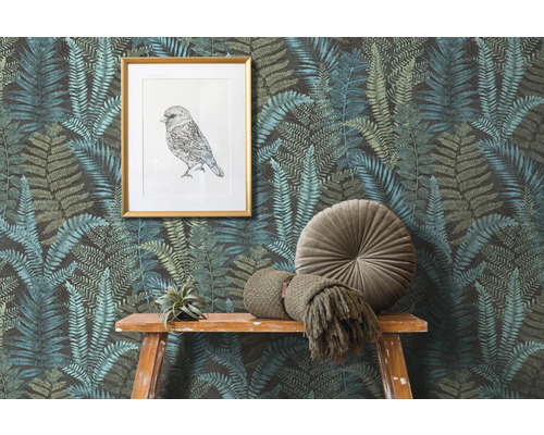 Scène avec papier peint à motifs de fougères, une image d''oiseau encadrée et des décorations sur une table en bois