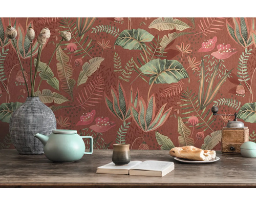 Nature morte décorative avec papier peint floral, théière, vaisselle et livre sur une table