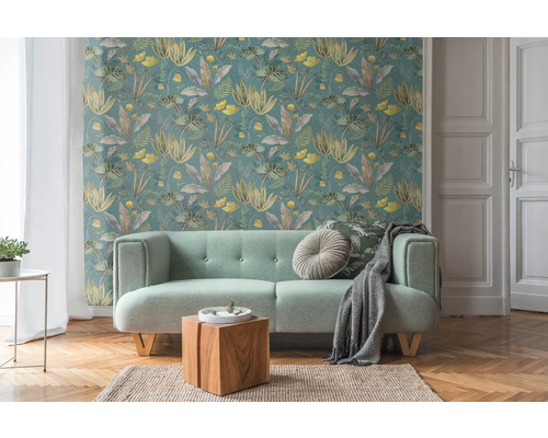 Salon avec papier peint floral, canapé, table en bois et tapis