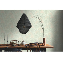 Esszimmer mit Esstisch, Geschirr, Teekanne, Kerzenständer, Lampe und floral gemusterter Tapete