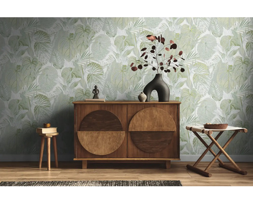 Wohnraum mit grüner Blättertapete, Holzkommode und Dekoration