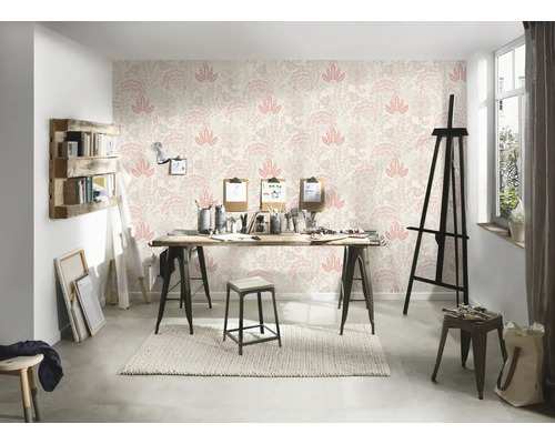 Ein helles Atelier mit einer gemusterten Tapete, einem Holztisch und verschiedenen Künstlerutensilien.