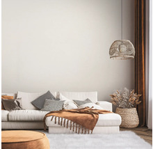 Helles Wohnzimmer mit Sofa, Kissen, Decke, Lampe und Dekoration
