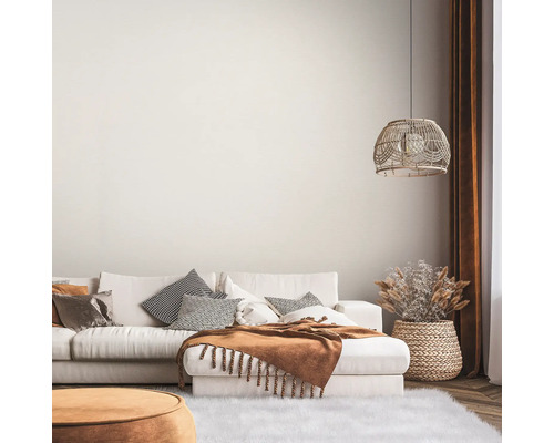 Salon lumineux avec canapé, coussins, couverture, lampe et décoration