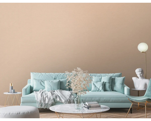 Wohnzimmer mit Sofa, Sessel, Dekoration und beiger Wandtapete.