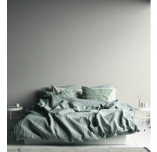 Helles Schlafzimmer mit Bett, Nachttischen und dekorativen Elementen.