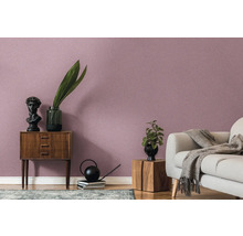 Wohnzimmer mit gemusterter Tapete, Sofa und Holzmöbeln