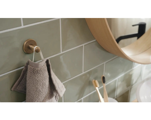 Vue de salle de bain avec crochet pour serviette, serviette, miroir et carreaux