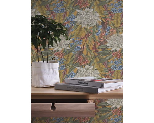 Blumentapete mit floralem Muster hinter einem Tisch mit Pflanze und Büchern
