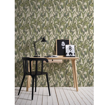 Einrichtungsbeispiel mit einem Schreibtisch, einer Lampe und einer gemusterten Tapete mit Pflanzenmotiven.