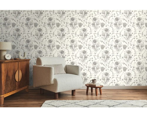 Wohnraum mit gemusterter Tapete, Sessel und Holzkommode