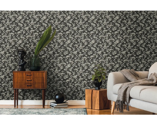 Salon décoratif avec papier peint à motifs floraux, commode et canapé.