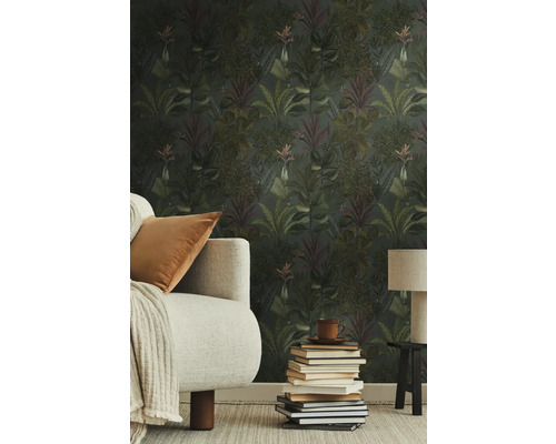 Salon avec papier peint jungle, canapé, lampe de table et pile de livres