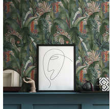 Scène avec papier peint à motifs avec des feuilles tropicales, une image encadrée et des objets décoratifs sur une étagère