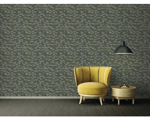 Pièce décorative avec papier peint à motifs floraux, fauteuil et lampe