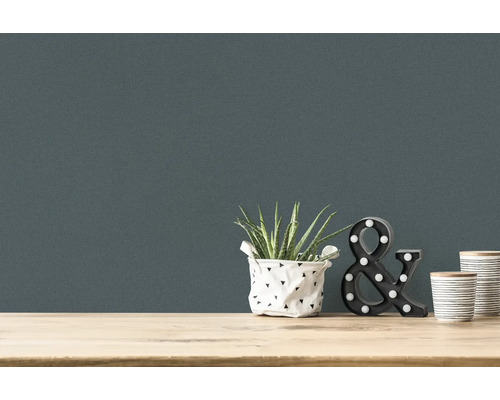 Nahaufnahme einer Wandtapete mit Zimmerpflanze, dekorativem Ampersand und zwei Bechern auf einem Tisch