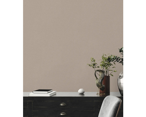 Commode décorative avec livres, objet d''art et plante dans une pièce lumineuse.