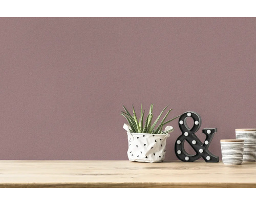 Nahaufnahme einer Wand mit Textiltapete und Dekoration auf einem Tisch