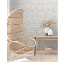 Hängesessel aus Rattan, Wandregal und Dekorationsvasen in einem hellen Raum.