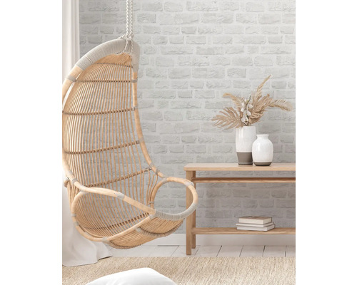 Hängesessel aus Rattan, Wandregal und Dekorationsvasen in einem hellen Raum.