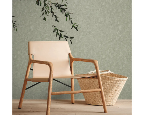 Szene mit einem Sessel mit Holzrahmen, einem beigen Sitz und einem Korb vor einer strukturierten Wand