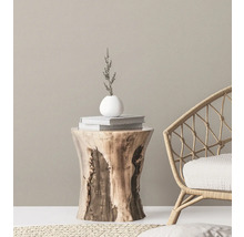 Dekorative Szene mit Holzhocker, Büchern, Vase und Korbsessel
