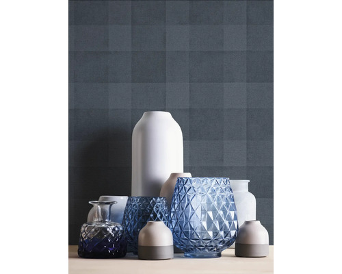 Verschiedene dekorative Vasen auf einer Oberfläche vor einer gemusterten Wand