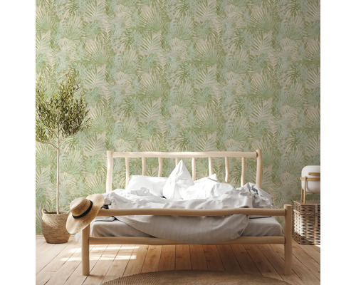 Schlafzimmer mit Bett vor einer grünen Blättertapete