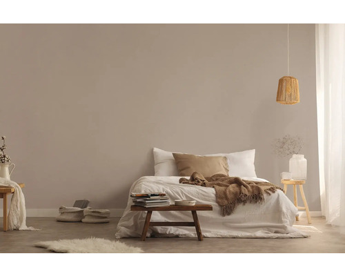 Chambre claire avec lit, tabouret en bois et suspension en rotin pour une atmosphère conviviale.