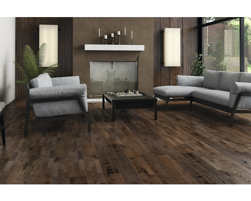 Wohnzimmer mit dunklem Holzboden, Sofa, Sessel und Couchtisch