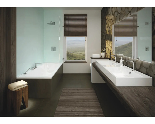 Salle de bain avec baignoire, deux lavabos et mur en pierre