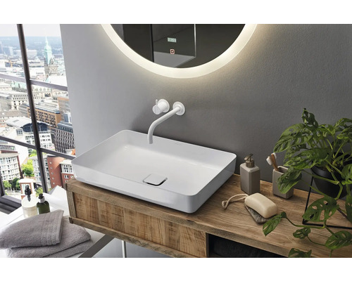 Salle de bains avec lavabo à poser, robinetterie et miroir avec éclairage sur un meuble-lavabo en bois