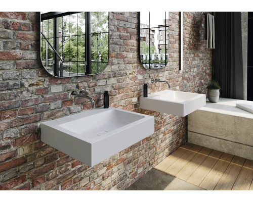 Salle de bains avec deux vasques à poser blanches sur un mur en briques avec des miroirs