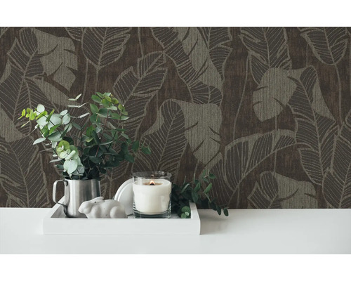 Dekorative Tapete mit Pflanzenmuster und ein Arrangement aus Kerze, Pflanze und Dekofigur auf einem Tisch