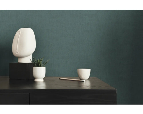 Dekorative Szene mit einer abstrakten Skulptur, einer Sukkulente und einem Bleistift auf einer Kommode.