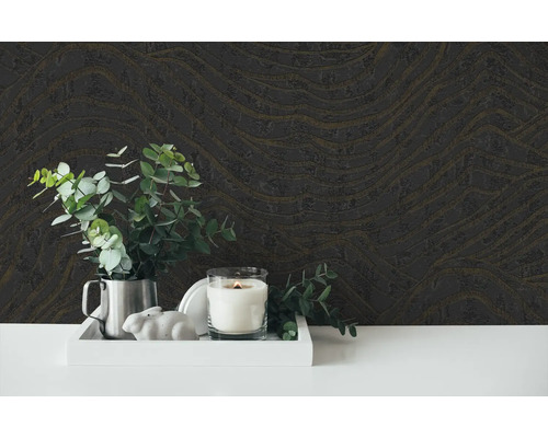 Dekoratives Arrangement mit gemusterter Tapete, Kerze, Pflanze und Zierfigur