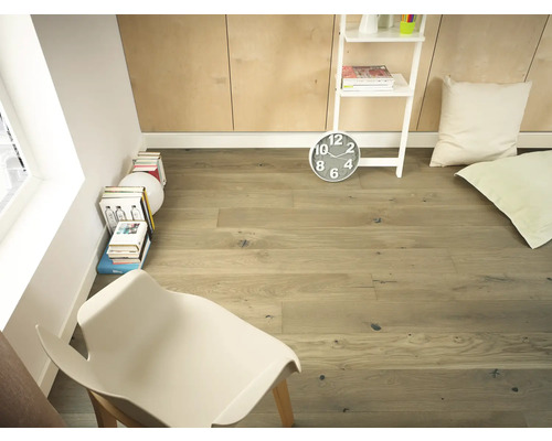 Pièce claire avec plancher en bois, étagère échelle, horloge, coussins et chaise.