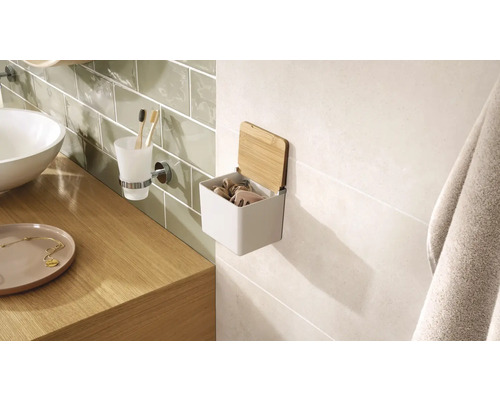 Intérieur de salle de bains avec lavabo, gobelet à brosse à dents et boîte de rangement murale avec couvercle en bambou