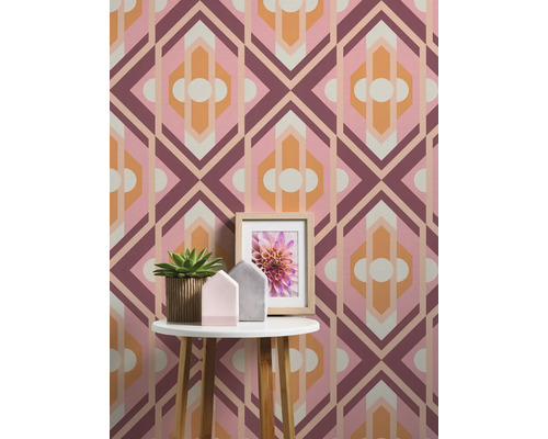 Raumansicht mit geometrischer Tapete, Beistelltisch, Topfpflanze und Bilderrahmen