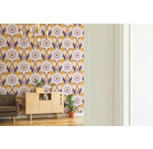 Wohnzimmer mit gemusterten Tapeten, Schrank, Sessel, Zimmerpflanze und Stehlampe
