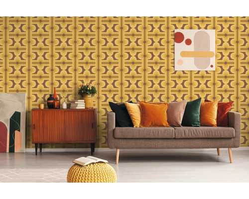 Szene eines Wohnzimmers mit brauner Couch, gelbem Pouf und einer Wand mit Retro Tapete.