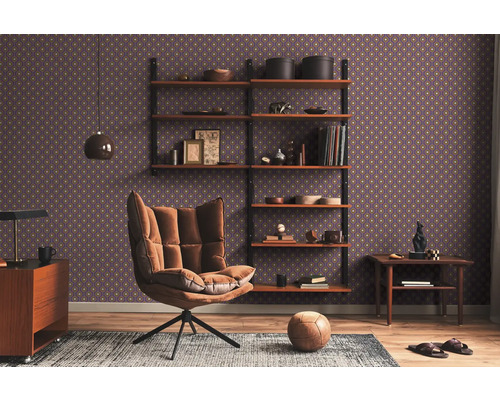 Wohnzimmer mit Sessel, Regal und gemusterter Tapete