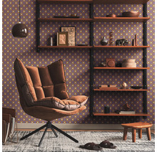 Wohnzimmer mit Ohrensessel, Regal und gemusterter Tapete für eine gemütliche Atmosphäre