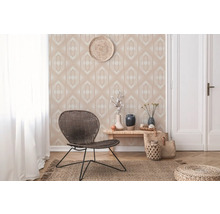 Dekoratives Wohnzimmer mit gemusterter Tapete, Rattansessel und Holzboden