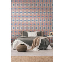 Schlafzimmer mit gemusterten Tapeten, Bett und Teppich für eine wohnliche Atmosphäre.