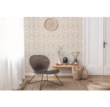 Pièce lumineuse avec papier peint géométrique, chaise en osier, table en bois et tapis de jute pour une ambiance conviviale.