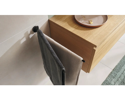 Zwei Handtücher hängen an einem Handtuchhalter neben einem Waschtisch.