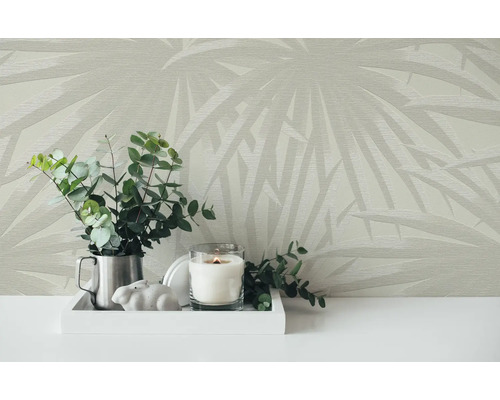 Scène avec papier peint à motifs, bougie, plantes et décoration sur une table